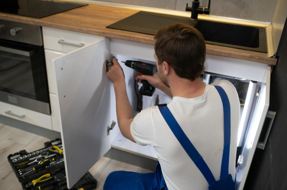 Cabinet installer measuring and fitting base cabinets for Dallas Cabinets KB